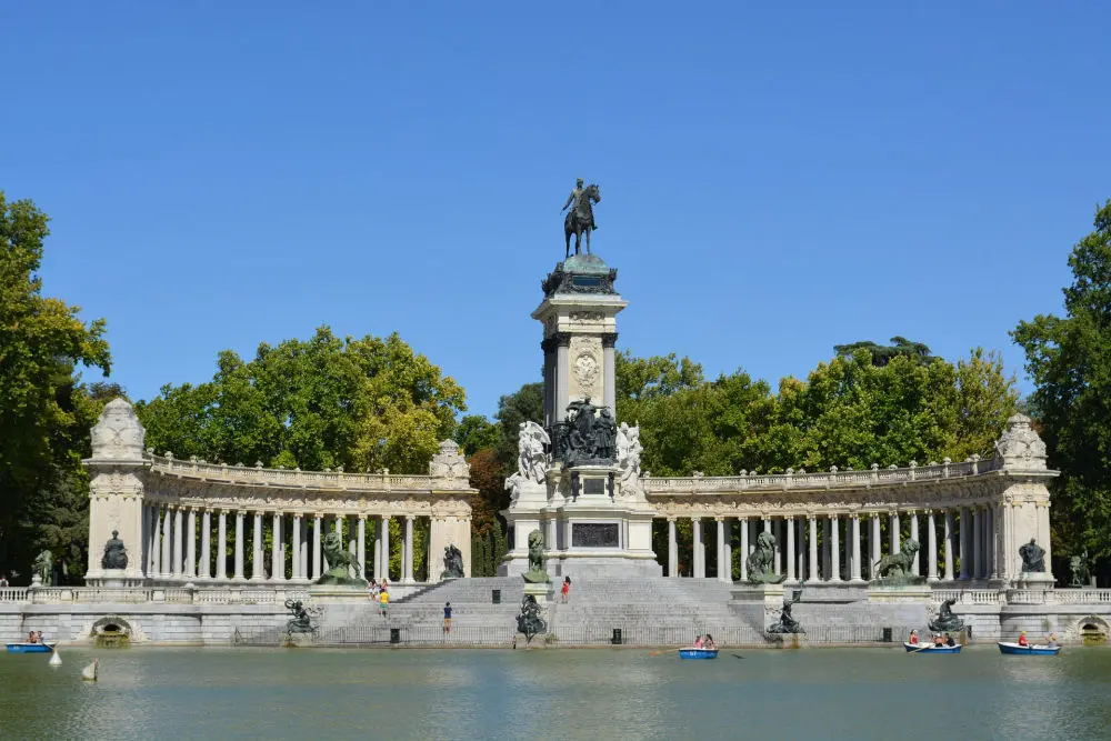 estanque de el retiro en una tarde calurosa con un cielo azul de intensidad increíble y parejas en las barcas remando 