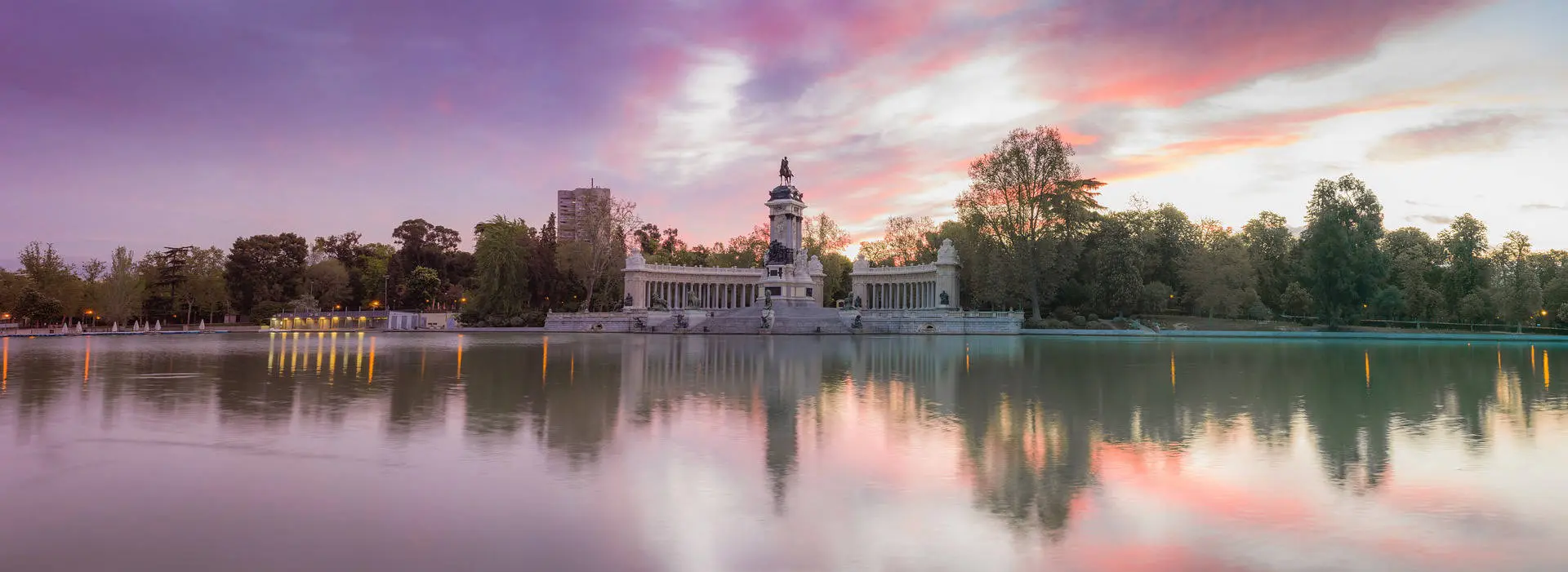 parque del retiro, el palacio de cristal en un atardecer de colores violetas y naranjas